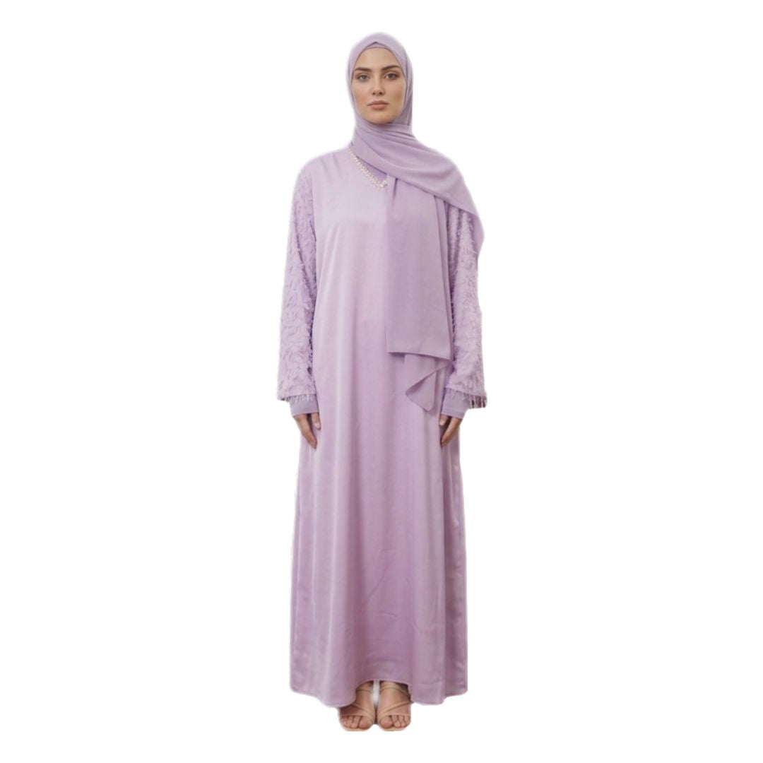 A woman modeling a light purple/lavender modest outfit consisting of a long-sleeved abaya with lace cuffs, a matching hijab, and a draped waist sash, shown against a plain white background.