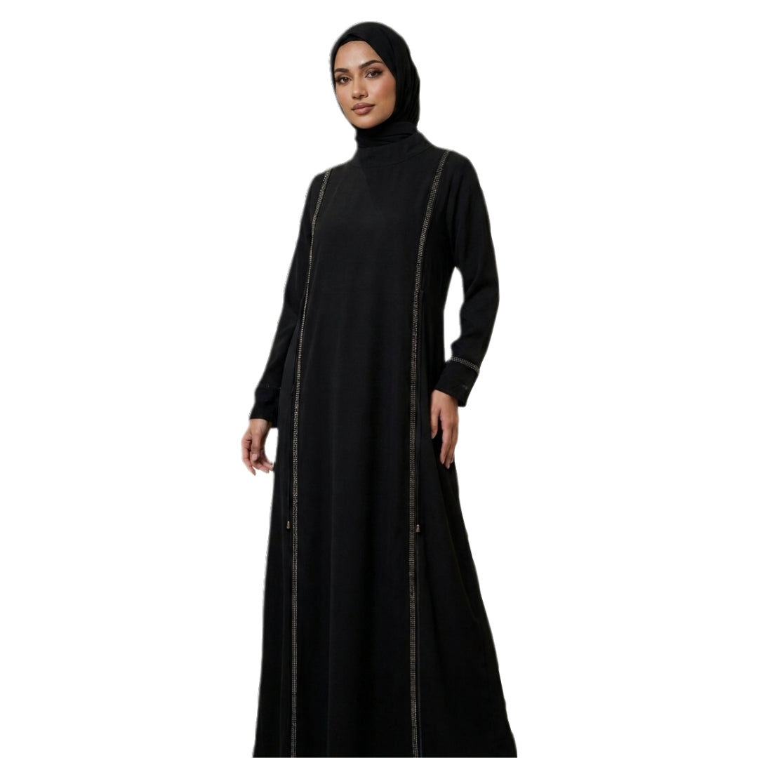 A woman wearing a long black abaya with subtle vertical metallic trim and a matching black hijab, standing against a plain white background.